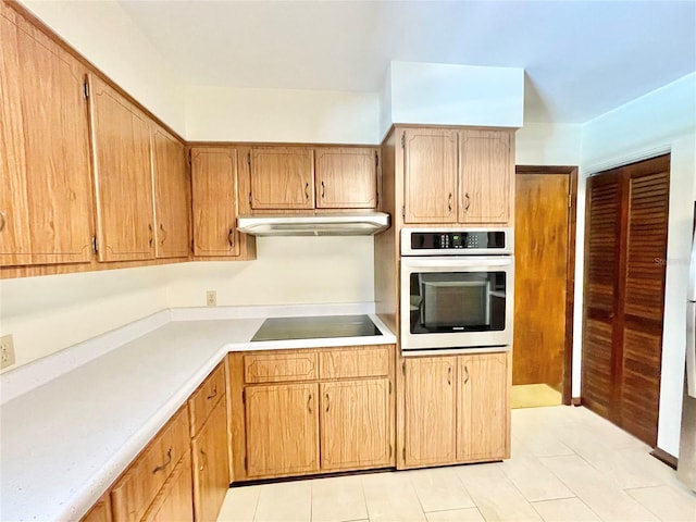 2268 NW 17th Ave, Gainesville, FL 32605 - kitchen featuring oven, black electric stovetop, under cabinet range hood, light countertops, and light tile patterned floors