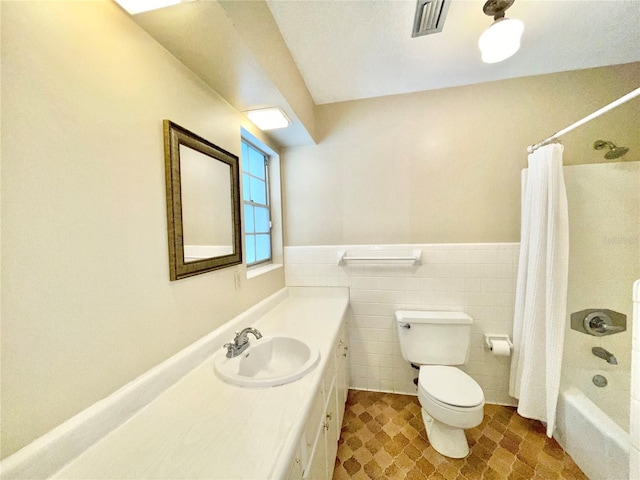 2268 NW 17th Ave, Gainesville, FL 32605 - full bath with shower / tub combo with curtain, vanity, tile walls, a wainscoted wall, and tile patterned flooring