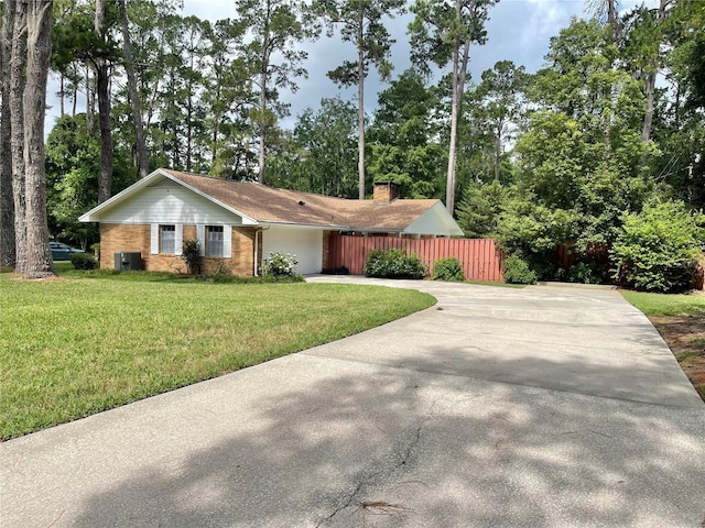 2268 NW 17th Ave, Gainesville, FL 32605 - ranch-style home featuring driveway, brick siding, a chimney, and view of wooded area
