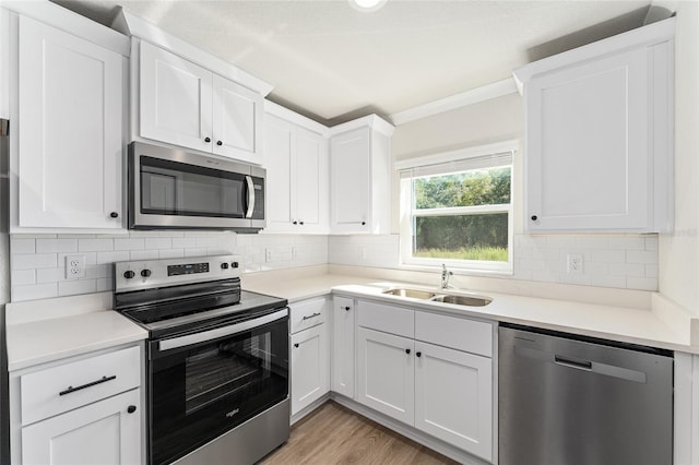 9011 N Travis Dr, Citrus Springs, FL 34434 - kitchen with stainless steel appliances, light wood finished floors, white cabinetry, light countertops, and tasteful backsplash