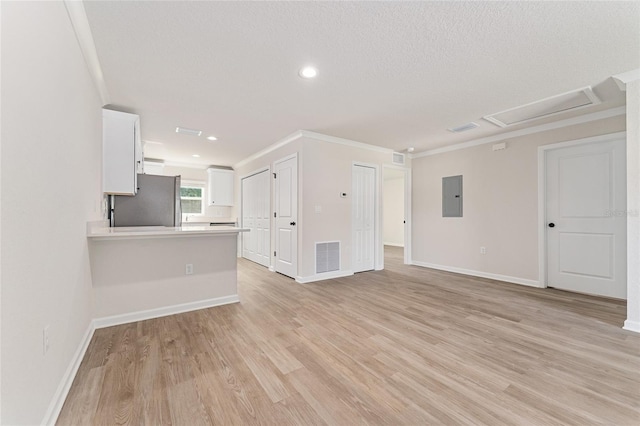 9011 N Travis Dr, Citrus Springs, FL 34434 - unfurnished living room featuring electric panel, light wood finished floors, crown molding, attic access, and recessed lighting