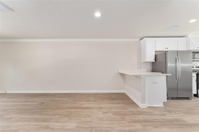 9011 N Travis Dr, Citrus Springs, FL 34434 - kitchen with appliances with stainless steel finishes, ornamental molding, light countertops, white cabinets, and light wood-type flooring