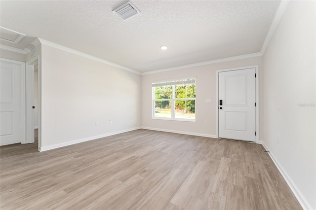 9011 N Travis Dr, Citrus Springs, FL 34434 - empty room with light wood-style flooring, crown molding, a textured ceiling, and attic access