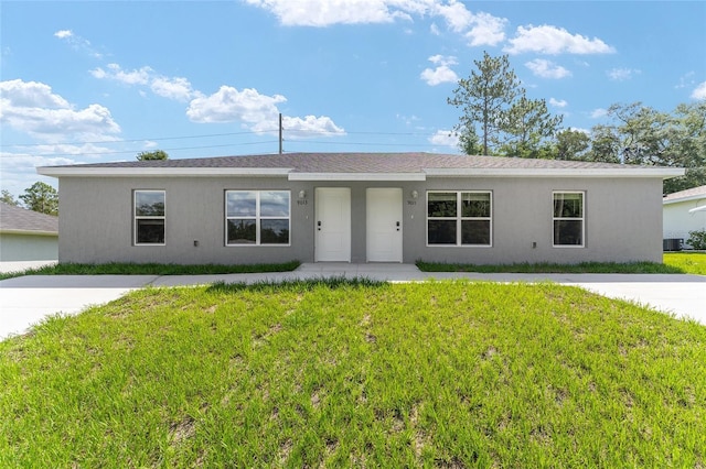 9011 N Travis Dr, Citrus Springs, FL 34434 - ranch-style home with a front lawn, stucco siding, and roof with shingles