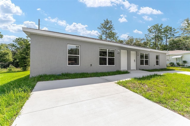 9011 N Travis Dr, Citrus Springs, FL 34434 - view of front of home featuring stucco siding, a front lawn, and a patio