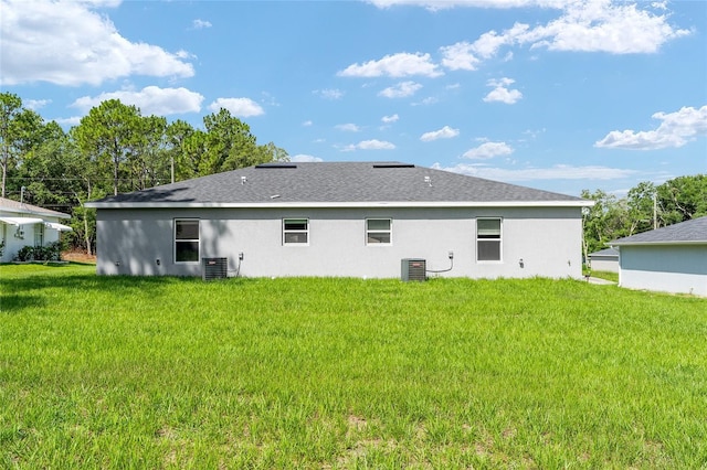 9011 N Travis Dr, Citrus Springs, FL 34434 - back of property with stucco siding, a lawn, and a shingled roof