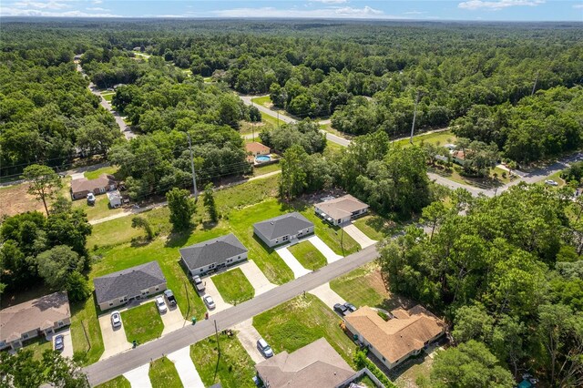 9011 N Travis Dr, Citrus Springs, FL 34434 - aerial perspective of suburban area with a heavily wooded area