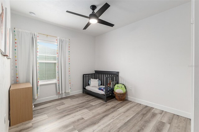 1425 SW 67th Dr, Gainesville, FL 32607 - bedroom with wood finished floors, a ceiling fan, and a nursery area