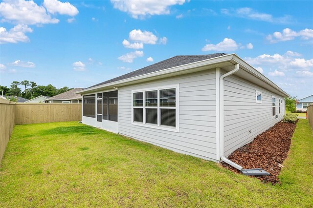 1425 SW 67th Dr, Gainesville, FL 32607 - back of house with a fenced backyard, a sunroom, and roof with shingles