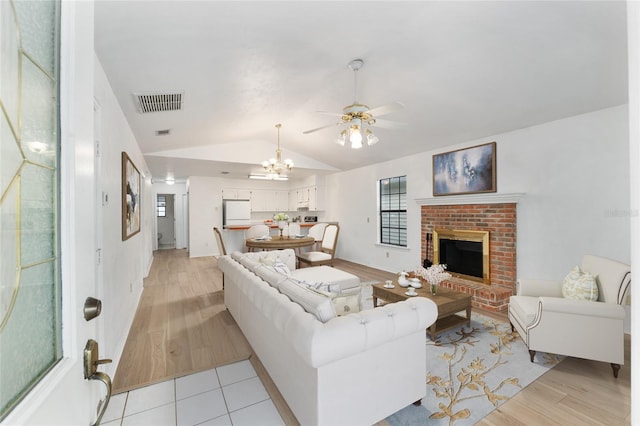 2963 SW 40th Ave, Gainesville, FL 32608 - living room with lofted ceiling, a fireplace, a ceiling fan, light wood-style floors, and a chandelier