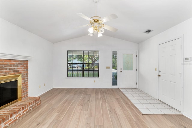 2963 SW 40th Ave, Gainesville, FL 32608 - unfurnished living room with vaulted ceiling, light wood-style flooring, a ceiling fan, and a fireplace