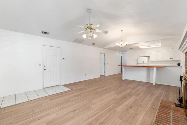 2963 SW 40th Ave, Gainesville, FL 32608 - unfurnished living room with vaulted ceiling, light wood finished floors, a ceiling fan, and a chandelier