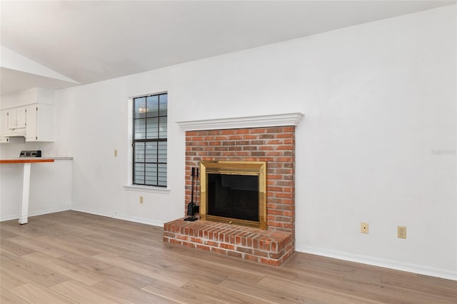 2963 SW 40th Ave, Gainesville, FL 32608 - unfurnished living room with a brick fireplace, light wood-type flooring, and lofted ceiling