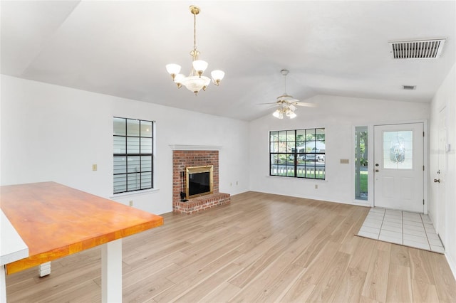 2963 SW 40th Ave, Gainesville, FL 32608 - unfurnished living room with lofted ceiling, light wood-style floors, a chandelier, ceiling fan, and a brick fireplace