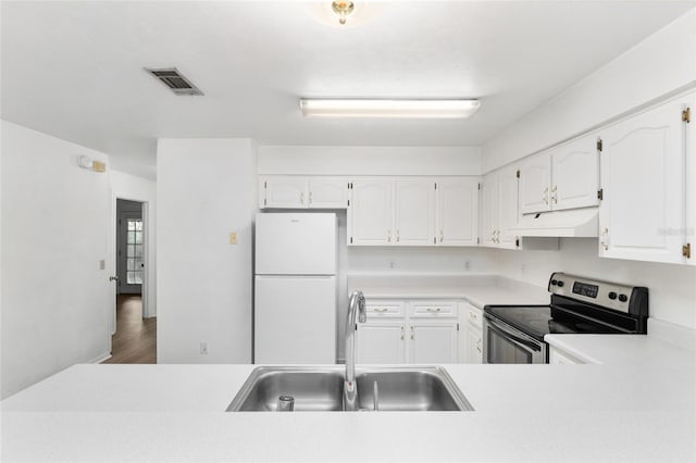 2963 SW 40th Ave, Gainesville, FL 32608 - kitchen featuring freestanding refrigerator, stainless steel electric range, under cabinet range hood, white cabinets, and light countertops