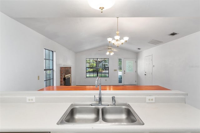 2963 SW 40th Ave, Gainesville, FL 32608 - kitchen featuring a chandelier, lofted ceiling, a brick fireplace, decorative light fixtures, and ceiling fan