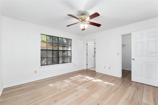 2963 SW 40th Ave, Gainesville, FL 32608 - unfurnished bedroom with light wood-type flooring, a walk in closet, a closet, and a ceiling fan