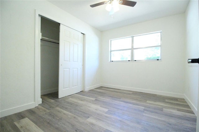 706 NE 24th St, Gainesville, FL 32641 - unfurnished bedroom featuring wood finished floors, ceiling fan, and a closet