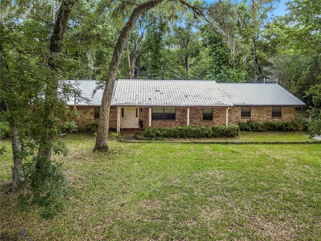 820 NW 109th Dr, Gainesville, FL 32606 - single story home with a front lawn, a metal roof, and brick siding