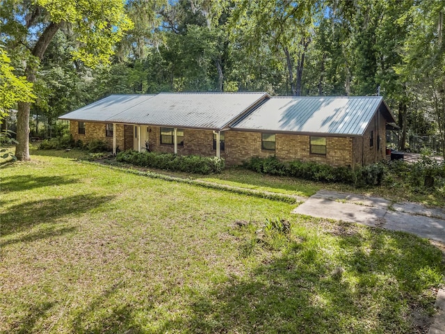 820 NW 109th Dr, Gainesville, FL 32606 - ranch-style house with a front lawn, a metal roof, and brick siding