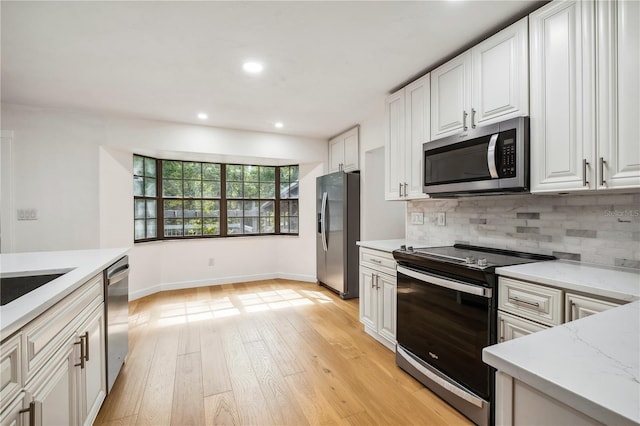 820 NW 109th Dr, Gainesville, FL 32606 - kitchen with stainless steel appliances, tasteful backsplash, light wood-type flooring, white cabinetry, and light stone counters