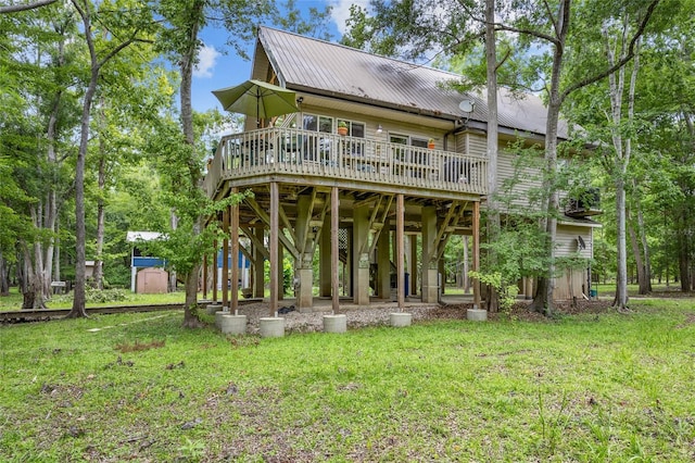174 SW Meridian Ct, Fort White, FL 32038 - rear view of property featuring a deck, a metal roof, a lawn, and a storage shed