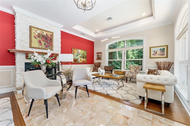 552 NW 136th St, Newberry, FL 32669 - living area with crown molding, a stone fireplace, a tray ceiling, a wainscoted wall, and recessed lighting