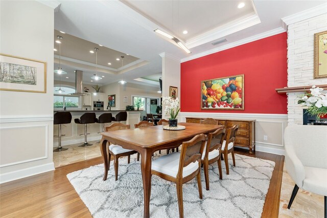 552 NW 136th St, Newberry, FL 32669 - dining room with a tray ceiling, a decorative wall, wood finished floors, ornamental molding, and healthy amount of natural light