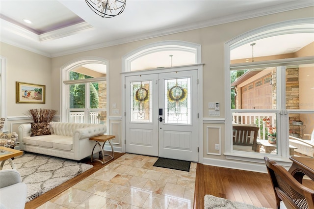 552 NW 136th St, Newberry, FL 32669 - foyer entrance featuring ornamental molding, healthy amount of natural light, a chandelier, a wainscoted wall, and a decorative wall
