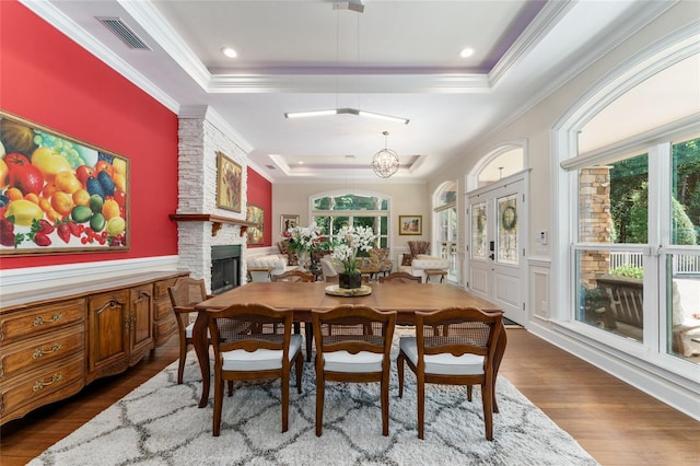 552 NW 136th St, Newberry, FL 32669 - dining space featuring a tray ceiling, crown molding, dark wood-type flooring, a fireplace, and wainscoting