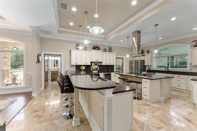 552 NW 136th St, Newberry, FL 32669 - kitchen with a spacious island, stainless steel fridge, island range hood, tasteful backsplash, and a kitchen bar