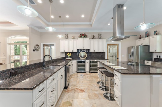 552 NW 136th St, Newberry, FL 32669 - kitchen with island exhaust hood, wine cooler, stainless steel appliances, a raised ceiling, and tasteful backsplash