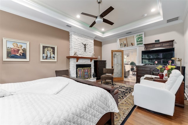 552 NW 136th St, Newberry, FL 32669 - bedroom with wood finished floors, crown molding, a fireplace, a tray ceiling, and recessed lighting