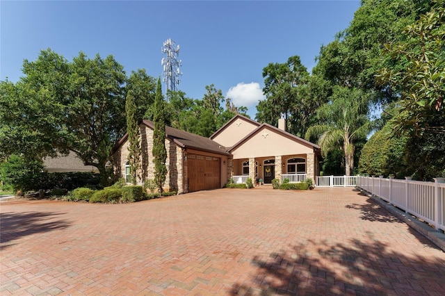 552 NW 136th St, Newberry, FL 32669 - view of front of property featuring covered porch, an attached garage, and decorative driveway