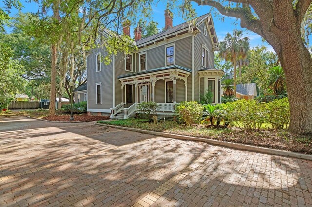 708 E University Ave, Gainesville, FL 32601 - view of front of house featuring covered porch and a chimney