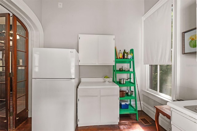 708 E University Ave, Gainesville, FL 32601 - kitchen with freestanding refrigerator, white cabinetry, dark wood-type flooring, and light countertops