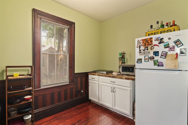 708 E University Ave, Gainesville, FL 32601 - kitchen featuring freestanding refrigerator, a wainscoted wall, dark wood-style floors, and white cabinetry