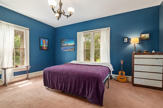 708 E University Ave, Gainesville, FL 32601 - carpeted bedroom featuring a chandelier and baseboards