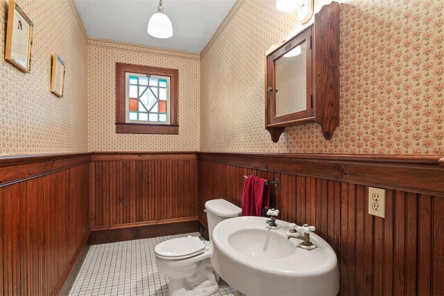 708 E University Ave, Gainesville, FL 32601 - bathroom featuring wallpapered walls, a wainscoted wall, and tile patterned flooring