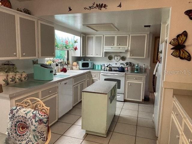 8411 N Pine Needle Ter, Crystal River, FL 34428 - kitchen with white appliances, a center island, light countertops, under cabinet range hood, and light tile patterned floors