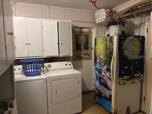 8411 N Pine Needle Ter, Crystal River, FL 34428 - laundry area featuring cabinet space, washing machine and clothes dryer, and a textured ceiling