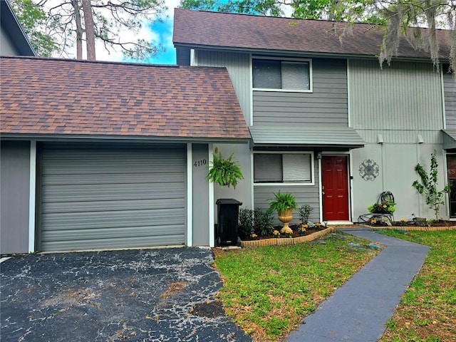 4110 NW 44th Dr Unit 0, Gainesville, FL 32606 - view of front of property with a shingled roof, asphalt driveway, and a garage