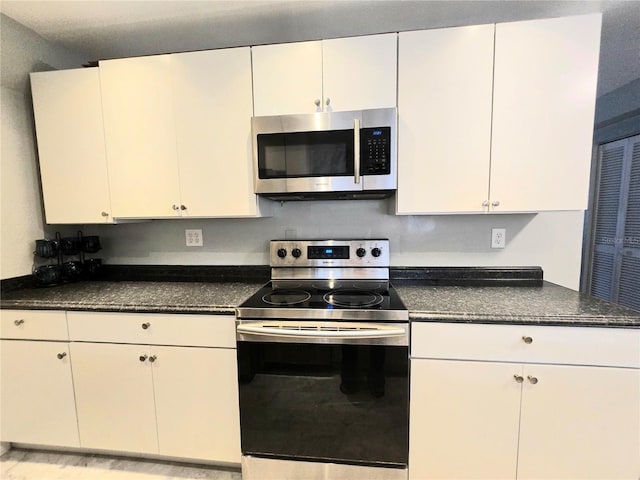 4110 NW 44th Dr Unit 0, Gainesville, FL 32606 - kitchen featuring appliances with stainless steel finishes, dark countertops, and white cabinets