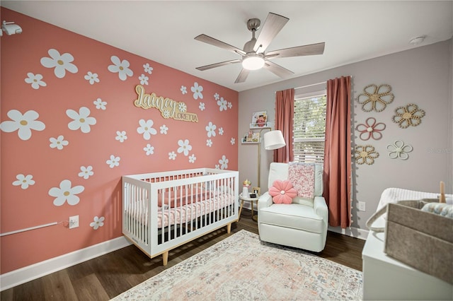 15591 NE 14th Pl, Williston, FL 32696 - bedroom featuring a nursery area, wood finished floors, wallpapered walls, and ceiling fan