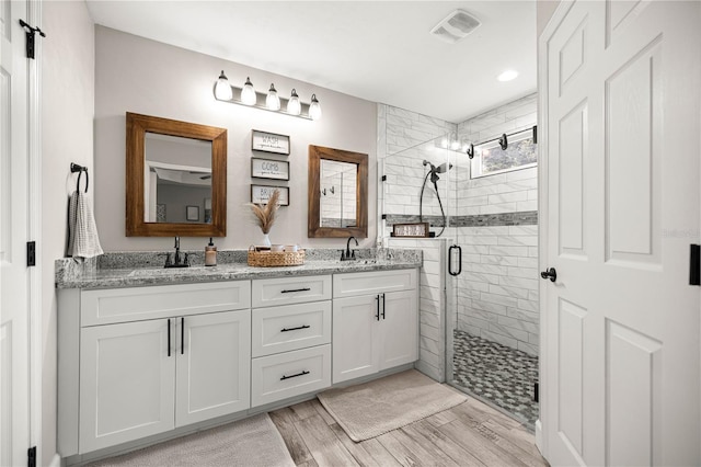 15591 NE 14th Pl, Williston, FL 32696 - full bathroom featuring a shower stall, double vanity, wood finished floors, and recessed lighting