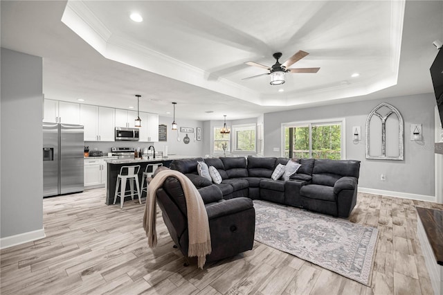 15591 NE 14th Pl, Williston, FL 32696 - living room featuring a tray ceiling, a ceiling fan, ornamental molding, light wood-type flooring, and recessed lighting