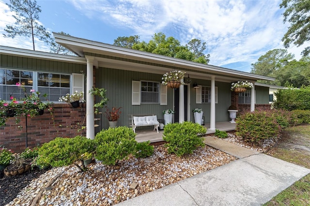 2223 NW 21st Ave, Gainesville, FL 32605 - view of exterior entry featuring covered porch and brick siding