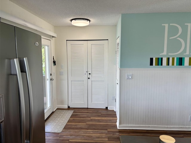 1536 S Central Ave, Flagler Beach, FL 32136 - foyer entrance featuring dark wood-style flooring, a wainscoted wall, and a textured ceiling