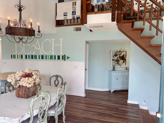 1536 S Central Ave, Flagler Beach, FL 32136 - dining area featuring dark wood-type flooring, a chandelier, a wainscoted wall, and stairs