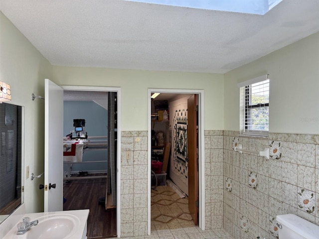 1536 S Central Ave, Flagler Beach, FL 32136 - bathroom with tile walls, a wainscoted wall, and vanity